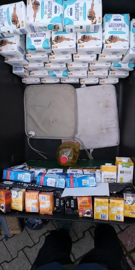 Verschiedene Milch- und Saftpackungen in einer Kiste, darunter eine Flasche Öl.